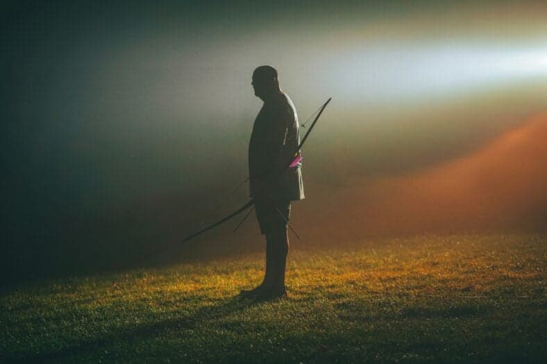 man silhouette with bow and arrows