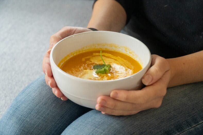 person holding bowl of soup