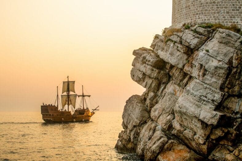 pirate ship near rock outcropping