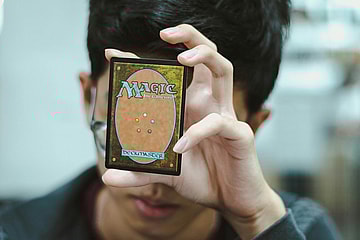 guy holding a magic the gathering card / most valuable magic the gathering cards