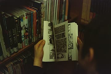 person flipping through comic book / 1940s war comics