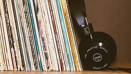 headphones leaning against vinyl records / 1980s movie soundtrack vinyl records