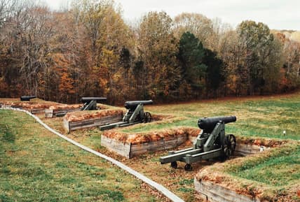 row of cannons on grass / american battlefields