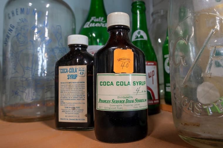 Old bottles of Coca Cola syrup on display with a collection of bottles at American Daydream Antiques & Miscellanea