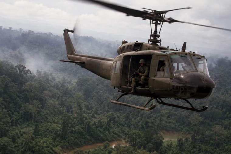 Artist impression of Vietnam-era U.S. helicopter over jungle.