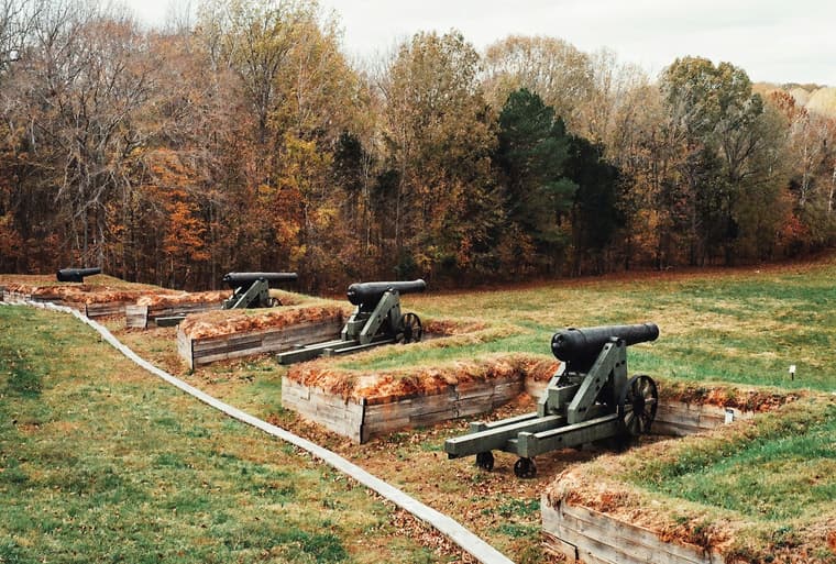 row of cannons on grass / american battlefields