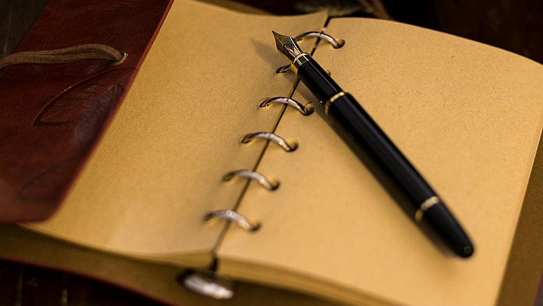 pen sitting on journal paper / iconic pen models