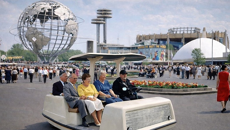 A bench with wheels taking people around a trades fair.