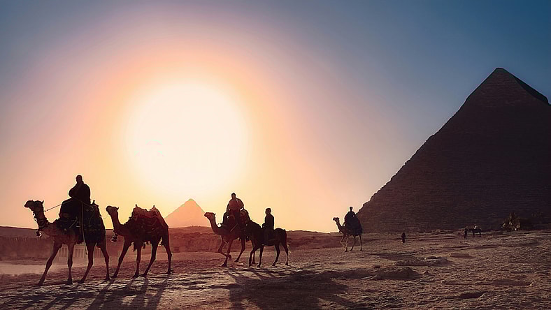 camels walking past pyramids / bizarre egyptian rituals