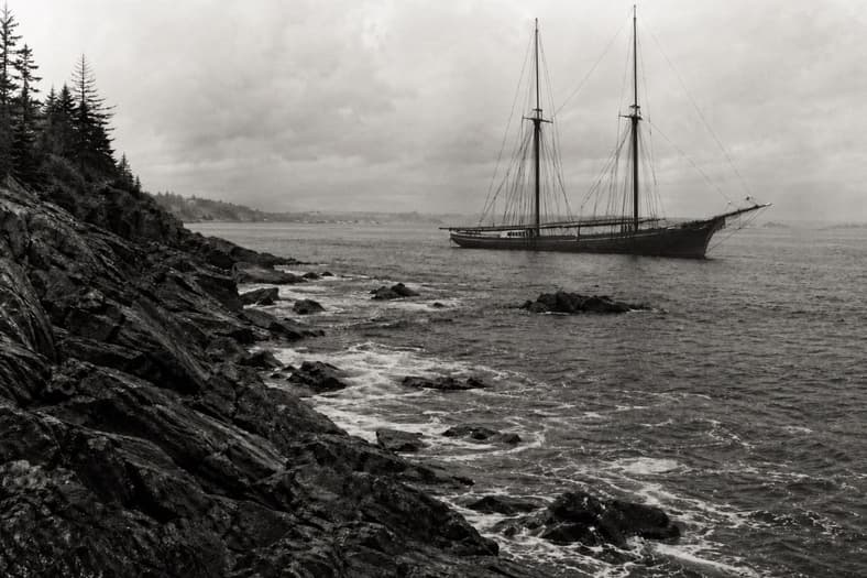 Artist impression of an old ship off a coast.