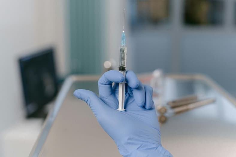 A syringe being held by a doctor.