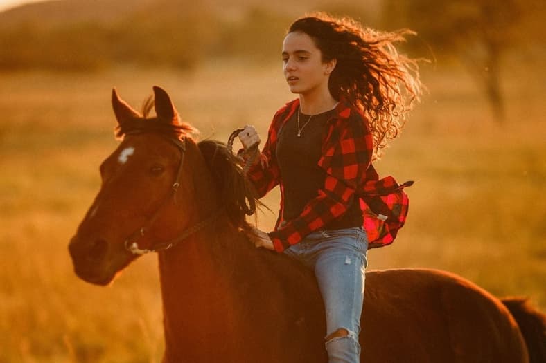 Young woman riding a horse.