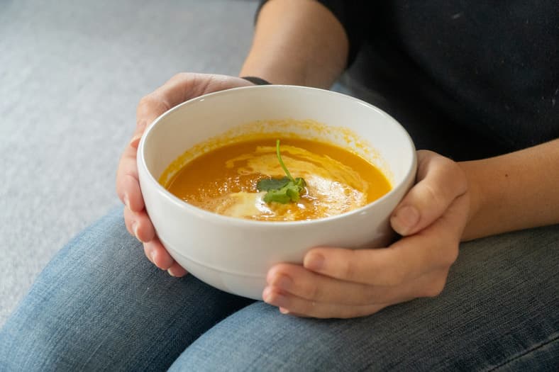 person holding bowl of soup