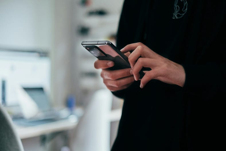 woman holding mobile phone in bank